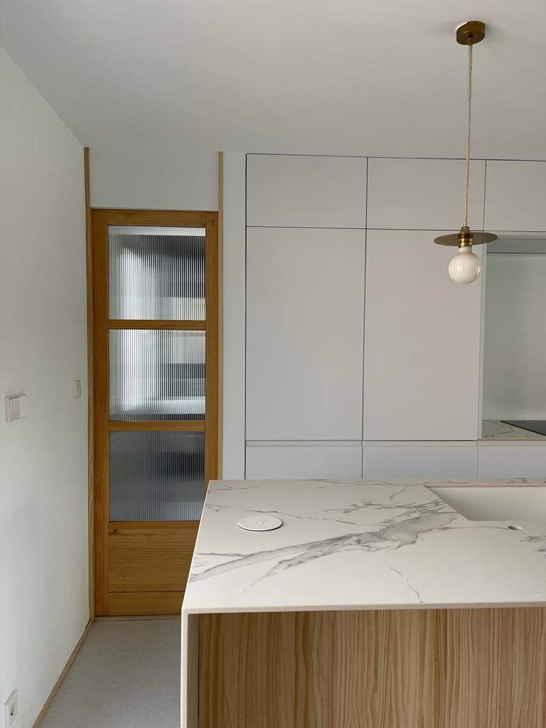 Cocina con isla central de mármol y diseño moderno en proyecto de interiorismo en Madrid